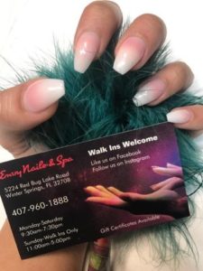 A person holding up their business card with fake nails on.